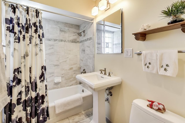 bathroom with toilet, shower / bath combination with curtain, and a sink