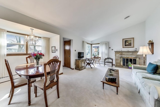 living area with a chandelier, lofted ceiling, a stone fireplace, and carpet