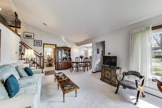 living room with lofted ceiling, stairway, a chandelier, carpet floors, and wallpapered walls