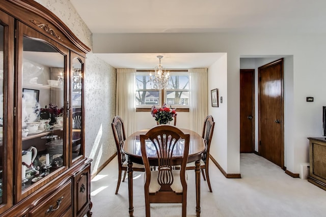 dining area featuring a chandelier, light carpet, and baseboards