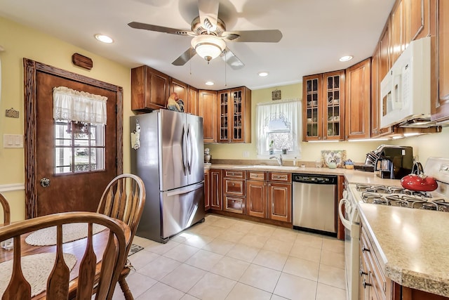 kitchen featuring appliances with stainless steel finishes, a ceiling fan, brown cabinetry, light countertops, and recessed lighting