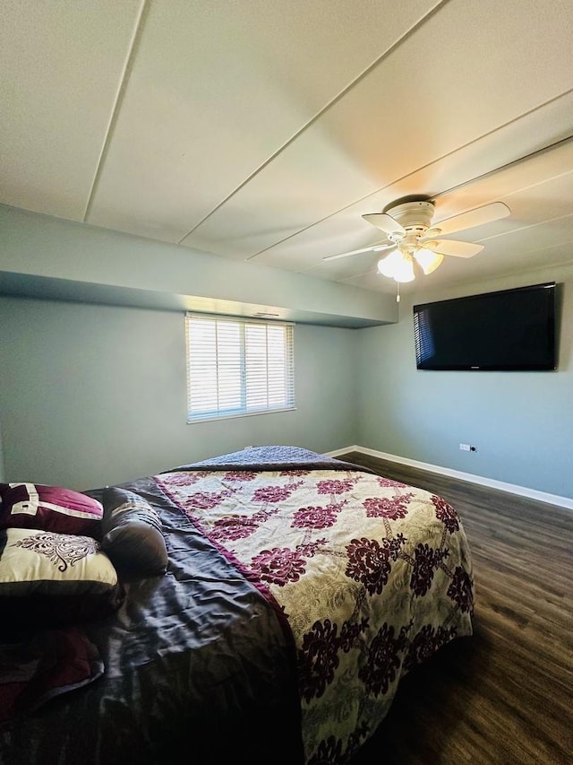 bedroom with wood finished floors, a ceiling fan, and baseboards
