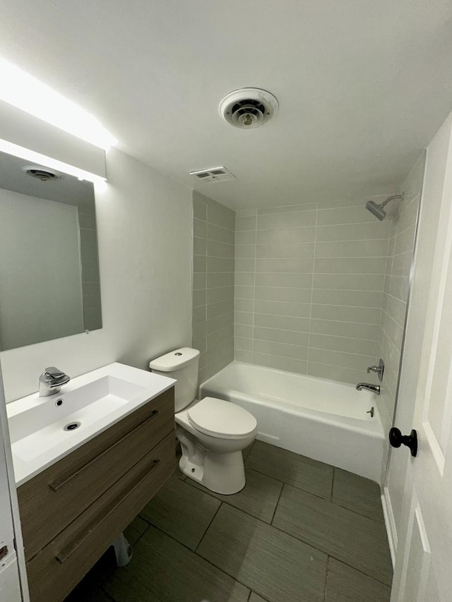 bathroom with tile patterned floors, vanity, shower / tub combination, and toilet