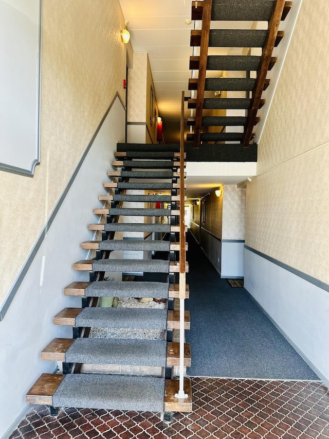 stairway featuring wallpapered walls