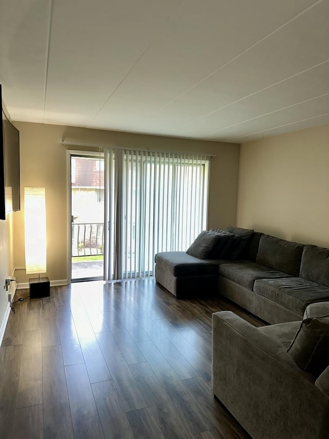 living area with plenty of natural light, dark wood-style flooring, and baseboards