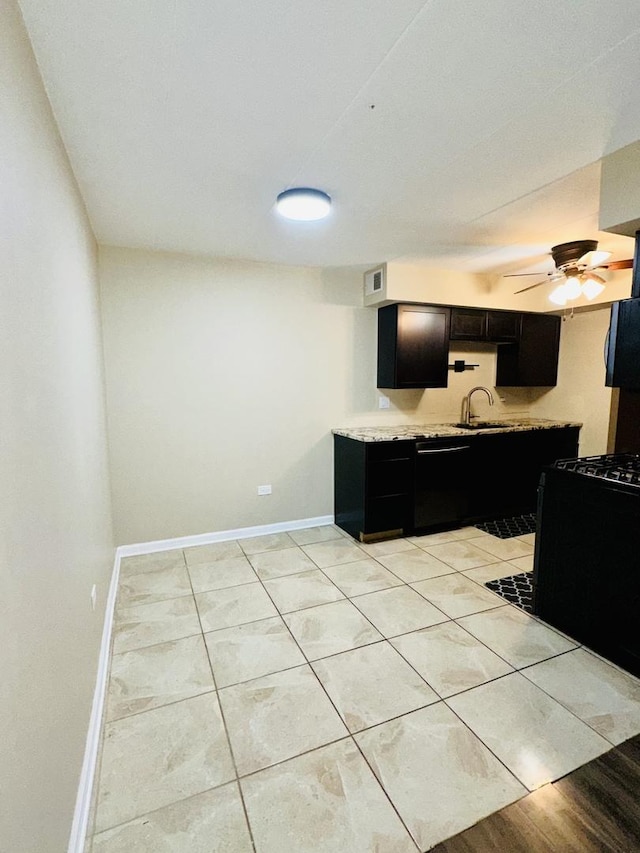 kitchen with dark cabinets, dishwasher, baseboards, a sink, and a ceiling fan