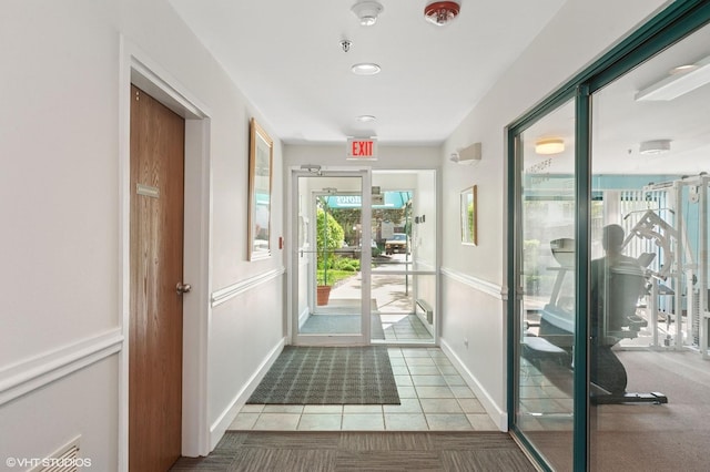 doorway to outside featuring tile patterned floors and baseboards