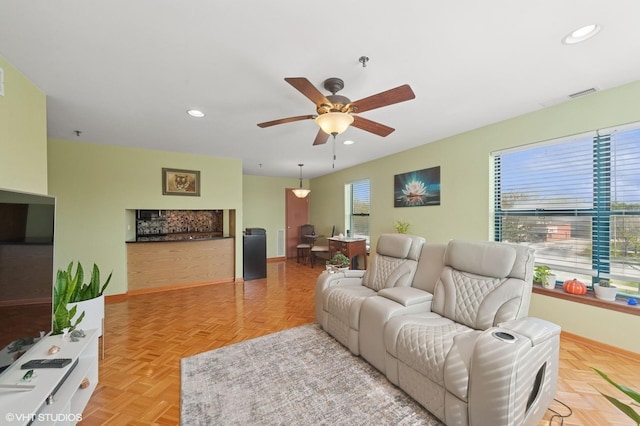 living area with ceiling fan, baseboards, and recessed lighting