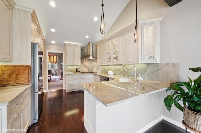 145 Princeton Ln, Glenview, IL 60026 - kitchen featuring wall chimney exhaust hood, a sink, appliances with stainless steel finishes, a peninsula, and light stone countertops