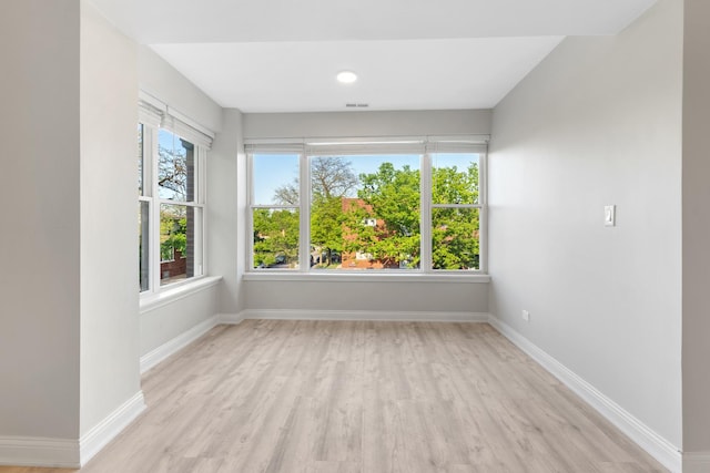 empty room featuring light wood finished floors and baseboards