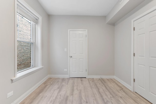 empty room with light wood-type flooring and baseboards