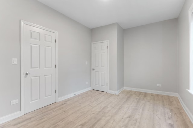 spare room with light wood finished floors and baseboards