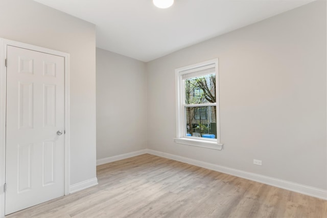empty room with light wood finished floors and baseboards