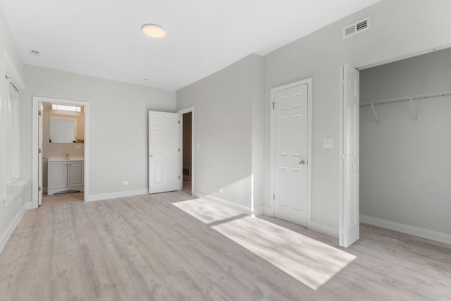 unfurnished bedroom with light wood-type flooring, baseboards, and a closet