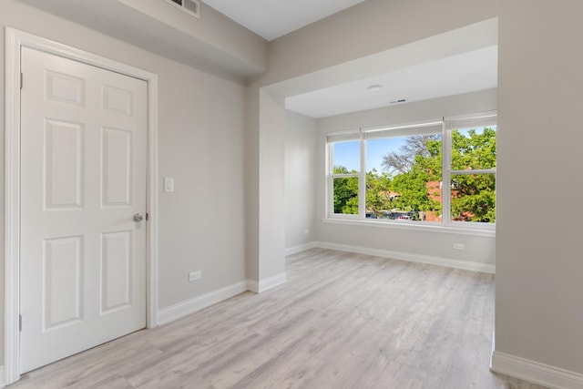 spare room with light wood-style floors and baseboards