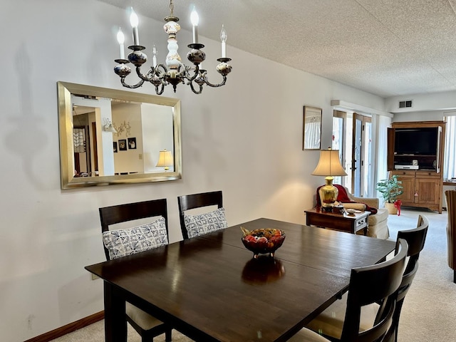 dining space with light colored carpet, a textured ceiling, visible vents, and a notable chandelier