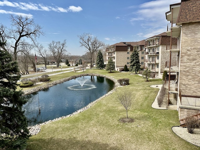 surrounding community with a water view and a yard
