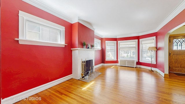 620 S Elmwood Ave, Oak Park, IL 60304 - unfurnished living room with wood finished floors, a fireplace, baseboards, arched walkways, and ornamental molding