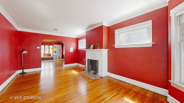 620 S Elmwood Ave, Oak Park, IL 60304 - unfurnished living room with arched walkways, a fireplace with flush hearth, baseboards, and wood finished floors