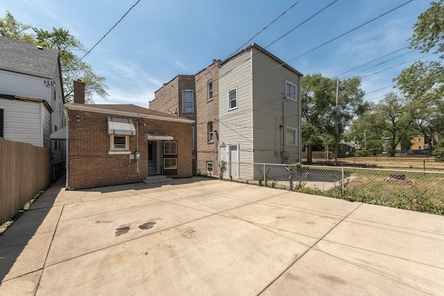 8007 S Houston Ave, Chicago, IL 60617 - rear view of house featuring brick siding, fence, and entry steps