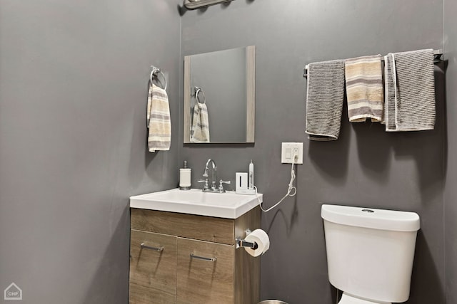 half bath featuring vanity and toilet