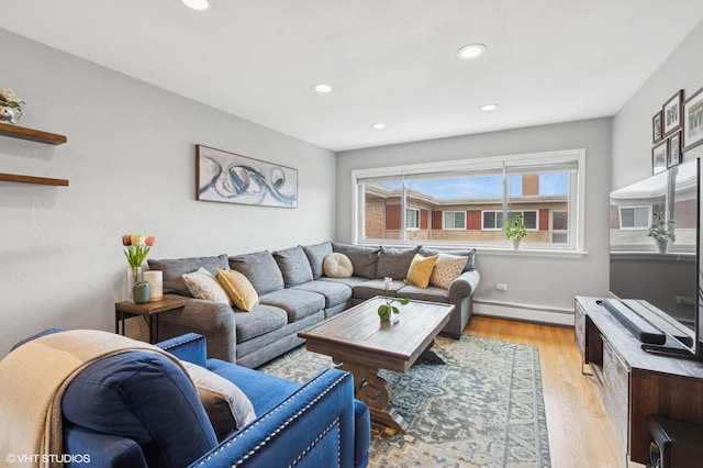 living area featuring a baseboard heating unit, light wood-style floors, and recessed lighting