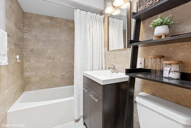 full bathroom featuring tile walls, shower / tub combo, vanity, and toilet