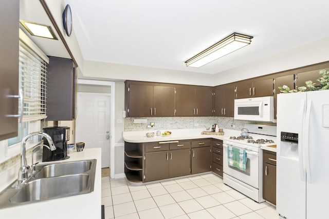 kitchen with white appliances, a sink, and dark brown cabinetry