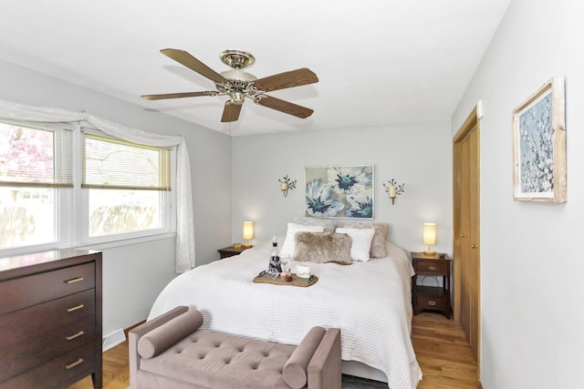 bedroom with wood finished floors, a ceiling fan, and baseboards