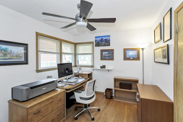 office space featuring light wood-style floors, a ceiling fan, and baseboards