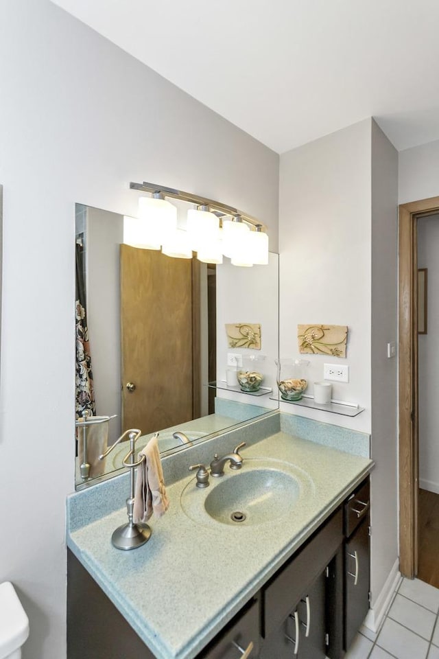 bathroom with vanity, tile patterned floors, toilet, and baseboards