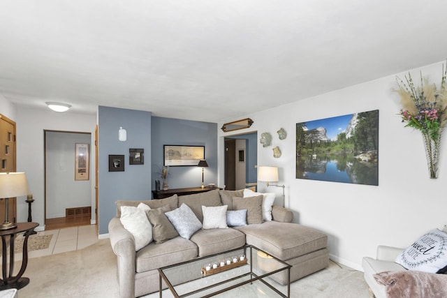living area featuring light carpet, light tile patterned flooring, and baseboards