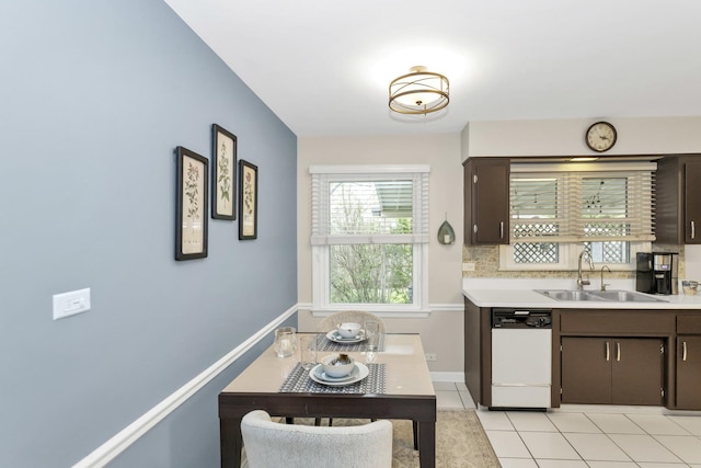 kitchen with a sink, dishwasher, dark brown cabinetry, and light countertops