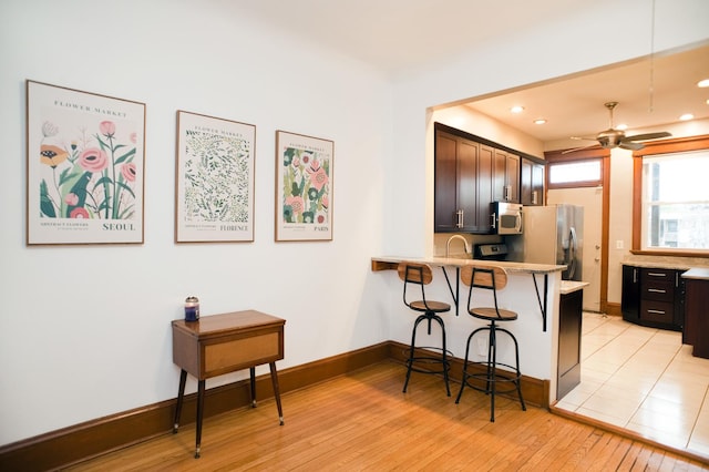 5338 S Greenwood Ave Unit 3, Chicago, IL 60615 - kitchen featuring appliances with stainless steel finishes, light countertops, a breakfast bar, a ceiling fan, and light wood finished floors