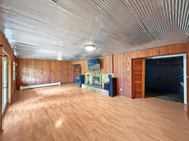 1612 Parkside Ct, Freeport, IL 61032 - unfurnished living room featuring baseboard heating, wooden walls, a fireplace, and wood finished floors