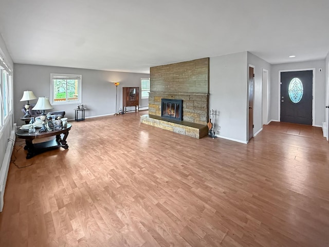 1612 Parkside Ct, Freeport, IL 61032 - living room with light wood-style flooring, baseboards, a stone fireplace, and baseboard heating