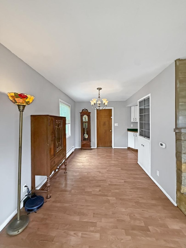 1612 Parkside Ct, Freeport, IL 61032 - unfurnished living room with a chandelier, a baseboard radiator, light wood finished floors, and baseboards