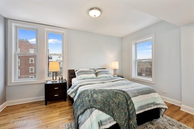 bedroom with light wood finished floors and baseboards