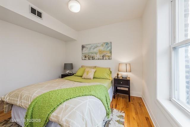 bedroom with visible vents, wood finished floors, and baseboards