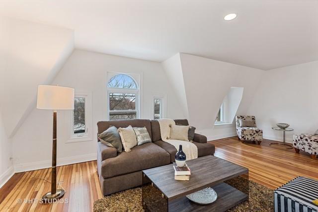 living area with vaulted ceiling, baseboards, and hardwood / wood-style floors