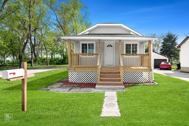 bungalow-style house with covered porch, a front lawn, a shingled roof, a detached garage, and an outdoor structure