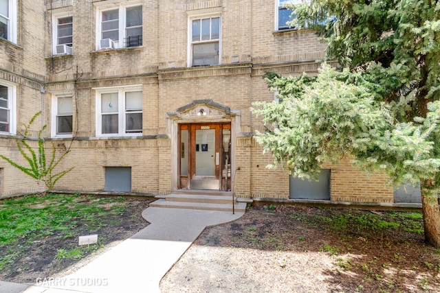 doorway to property featuring brick siding