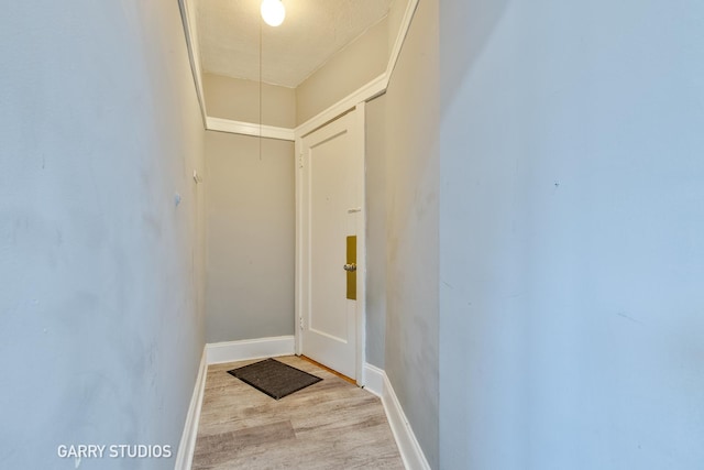 doorway to outside featuring wood finished floors and baseboards