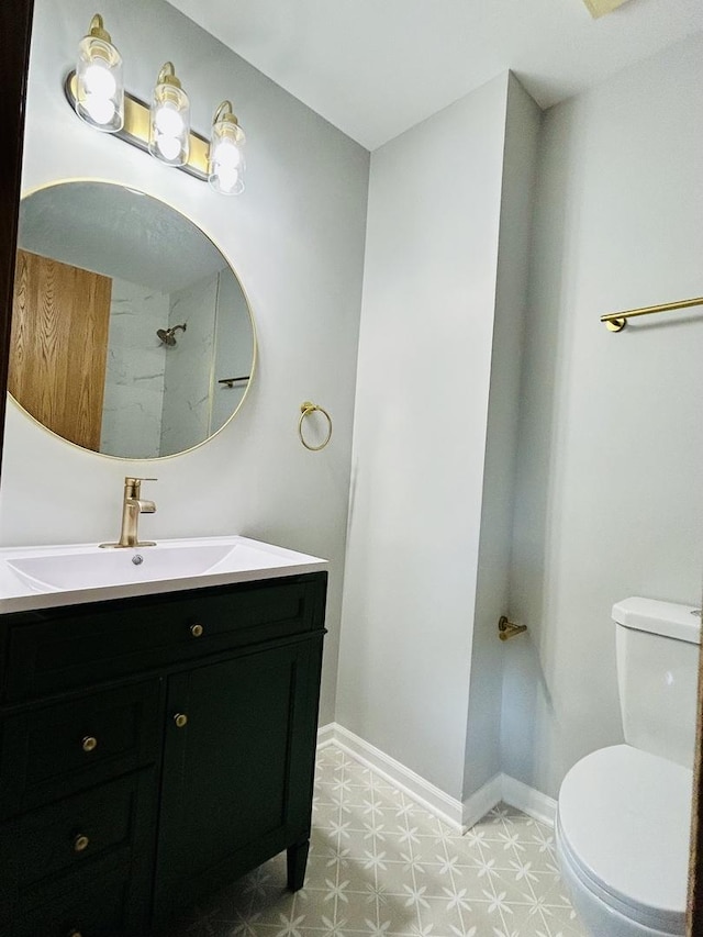 bathroom featuring vanity, toilet, baseboards, and tile patterned floors