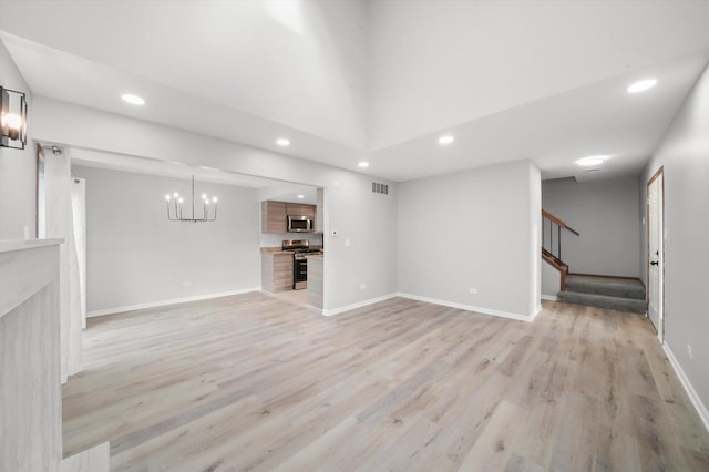 unfurnished living room with recessed lighting, stairway, light wood-style flooring, a chandelier, and baseboards
