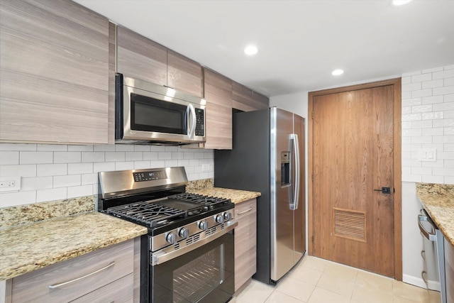 kitchen with appliances with stainless steel finishes, light stone countertops, recessed lighting, backsplash, and light tile patterned floors