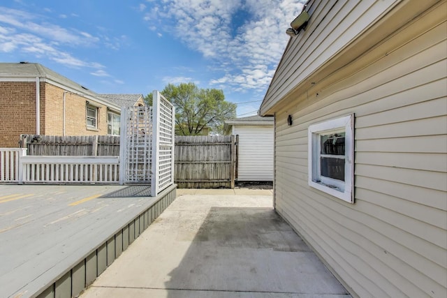 view of side of home with a deck, a patio area, and fence