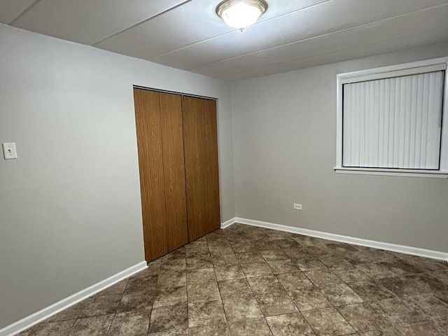 unfurnished bedroom with a closet and baseboards