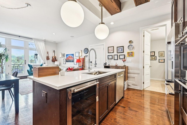 3940 N Ashland Ave Unit 2N, Chicago, IL 60613 - kitchen with wine cooler, a sink, dark wood-style floors, dark brown cabinets, and light countertops