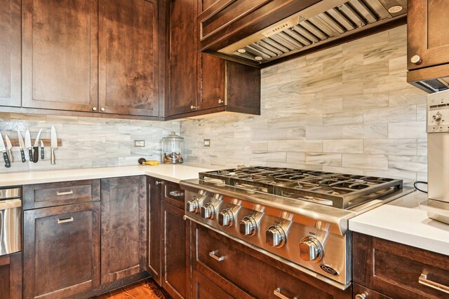 3940 N Ashland Ave Unit 2N, Chicago, IL 60613 - kitchen with stainless steel gas cooktop, custom range hood, decorative backsplash, light countertops, and wall oven